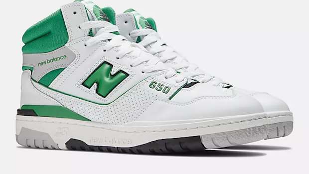 View of white and green New Balance shoes.